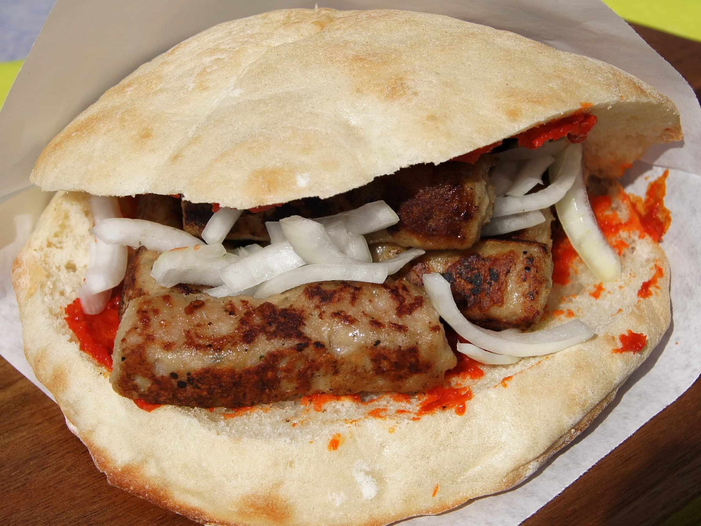 Cevapcici im Fladenbrot mit Ajvar, Zwiebeln und frischem Salat