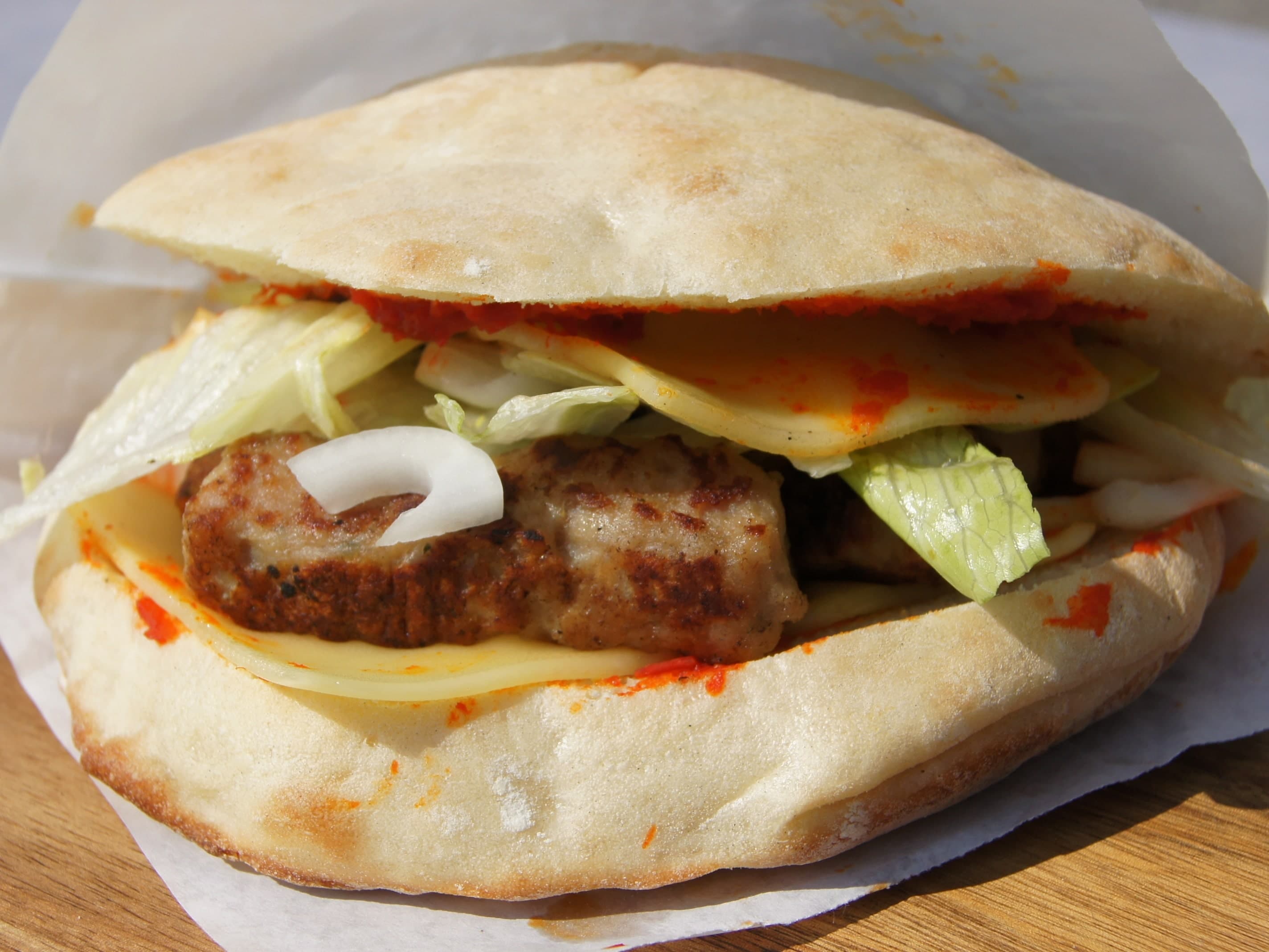 Cevapcici mit geschmolzenem Käse im warmen Fladenbrot